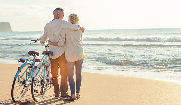 Pärchen mit Fahrrädern am Strand