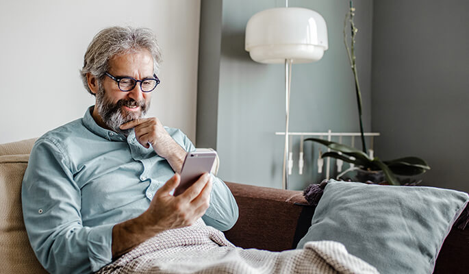 Mann mit Smartphone und den Apps der J&T Direktbank